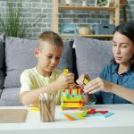 A mother and son building with coloured blocks