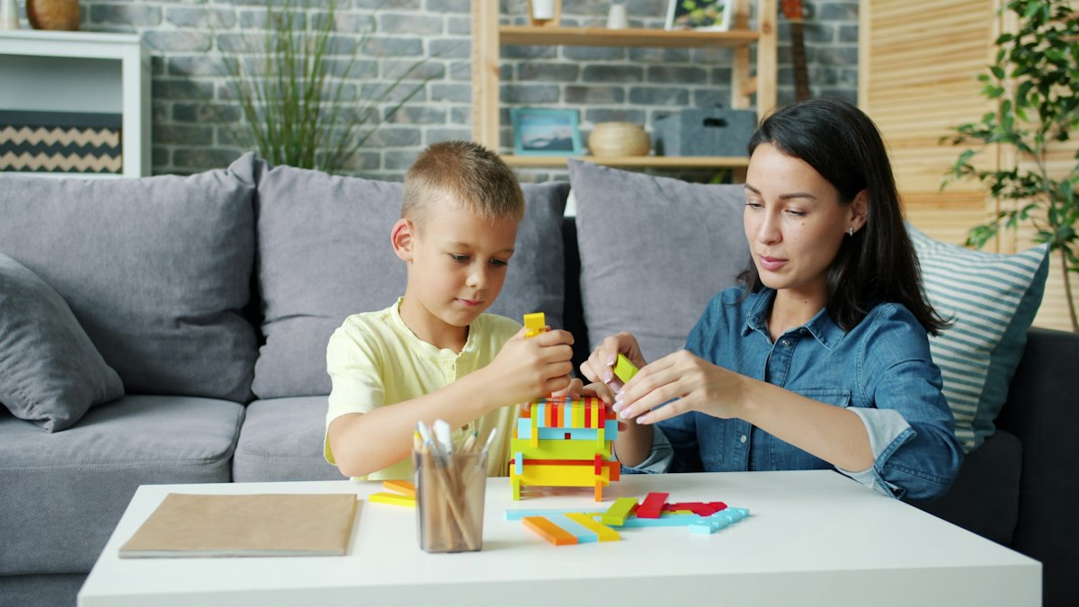 A mother and son building with coloured blocks